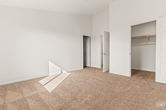 unfurnished bedroom featuring a spacious closet, high vaulted ceiling, a closet, and carpet flooring