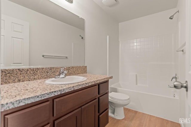 full bathroom featuring vanity, wood-type flooring, shower / bathtub combination, and toilet