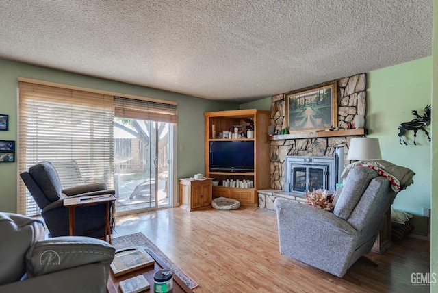 510 Sierra St, Taft, CA 93268 - living room with light wood-type flooring, a textured ceiling, and a fireplace