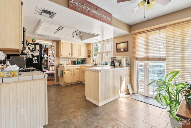 510 Sierra St, Taft, CA 93268 - kitchen featuring tile countertops, a ceiling fan, a raised ceiling, freestanding refrigerator, and a peninsula