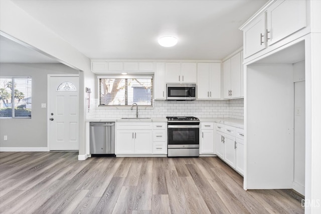 kitchen featuring white cabinetry, appliances with stainless steel finishes, light countertops, and a sink