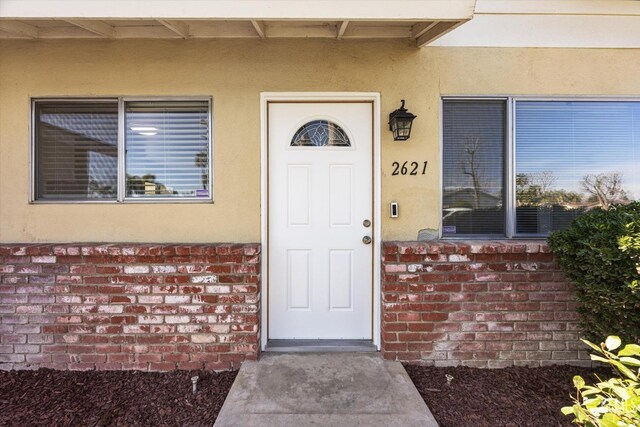 entrance to property with brick siding and stucco siding