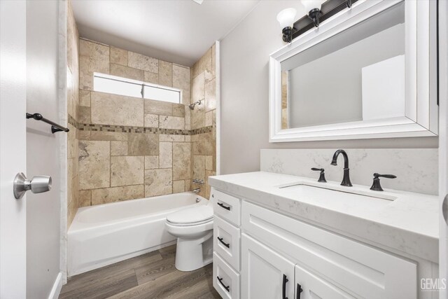 bathroom featuring shower / bath combination, toilet, wood finished floors, and vanity