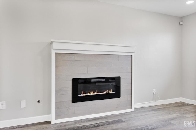 room details with recessed lighting, baseboards, wood finished floors, and a tile fireplace