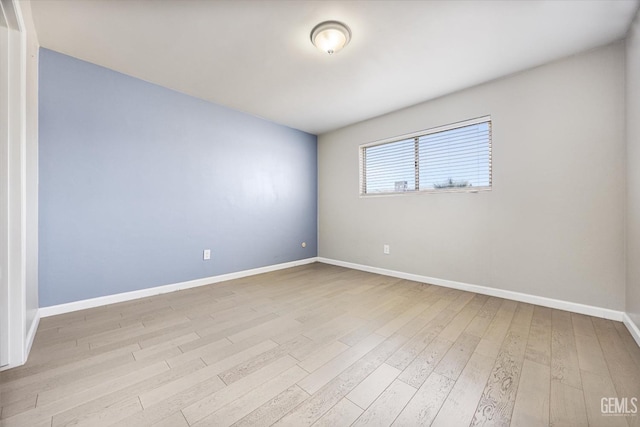 empty room with light wood-style floors and baseboards