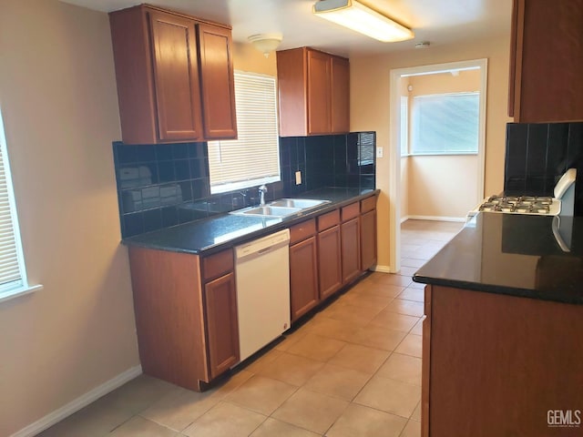 kitchen featuring light tile patterned floors, backsplash, white dishwasher, and sink