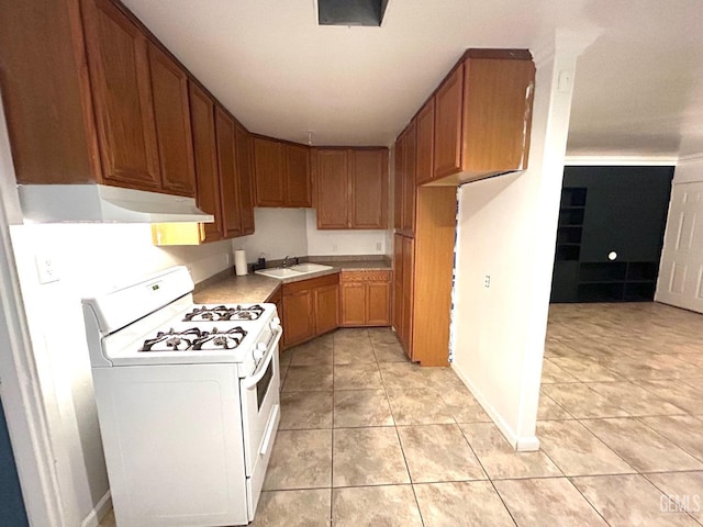 kitchen with sink, light tile patterned flooring, and white range with gas stovetop