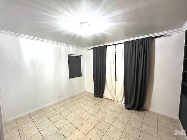 spare room with crown molding and light tile patterned floors