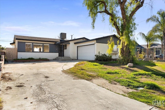 ranch-style house featuring a garage and cooling unit