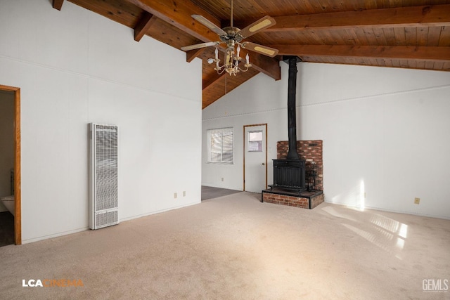 unfurnished living room featuring carpet flooring, ceiling fan, a wood stove, and wooden ceiling