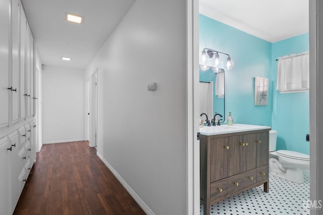 2513 Elm St, Bakersfield, CA 93301 - corridor featuring baseboards, a sink, and wood finished floors