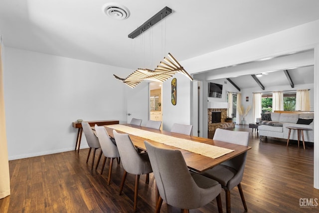 2513 Elm St, Bakersfield, CA 93301 - dining area with a stone fireplace, dark wood-style flooring, and baseboards