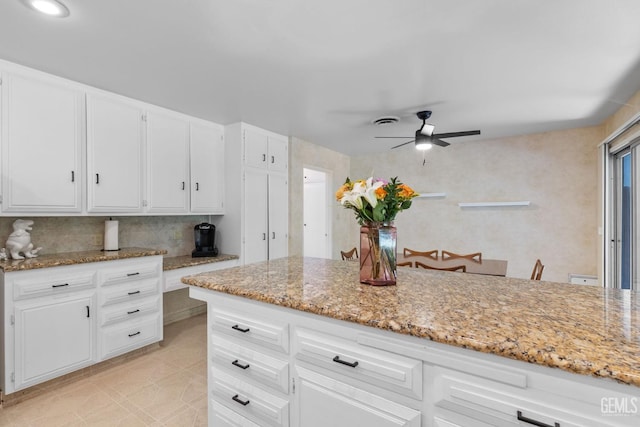 2513 Elm St, Bakersfield, CA 93301 - kitchen with a ceiling fan, light stone countertops, and white cabinetry