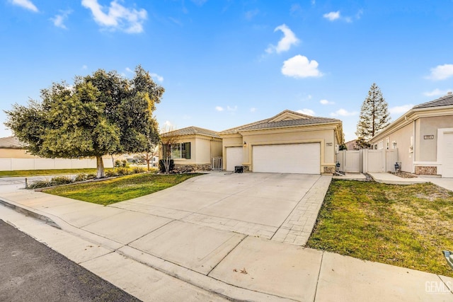 view of front of property featuring driveway, fence, a garage, a front lawn, and stucco siding