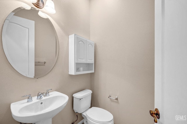 half bath with a sink and toilet