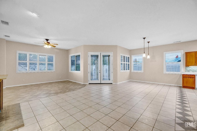 unfurnished living room featuring light tile patterned flooring, baseboards, ceiling fan, and visible vents