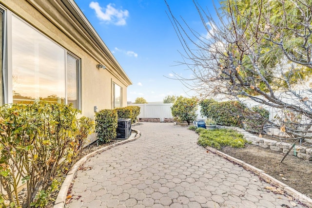 view of yard with fence, a patio, and central AC