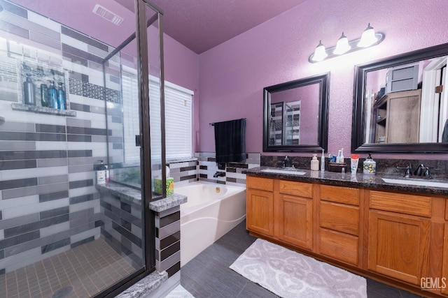 bathroom with tile patterned flooring, separate shower and tub, and vanity