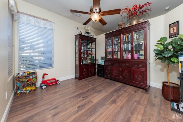 interior space with ceiling fan and dark hardwood / wood-style flooring