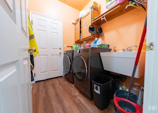 laundry area with cabinets, dark hardwood / wood-style flooring, independent washer and dryer, and sink