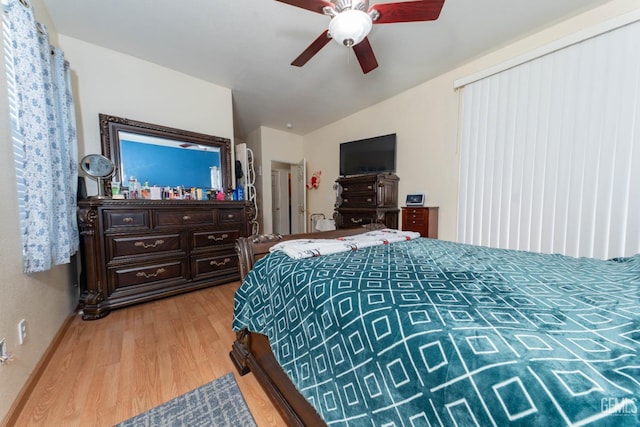 bedroom with ceiling fan, vaulted ceiling, and light wood-type flooring