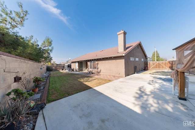 rear view of property with a lawn and a patio