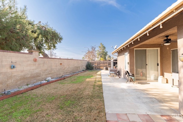 view of yard with ceiling fan and a patio