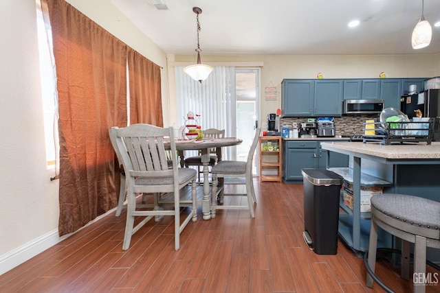 kitchen featuring hanging light fixtures, blue cabinets, and tasteful backsplash