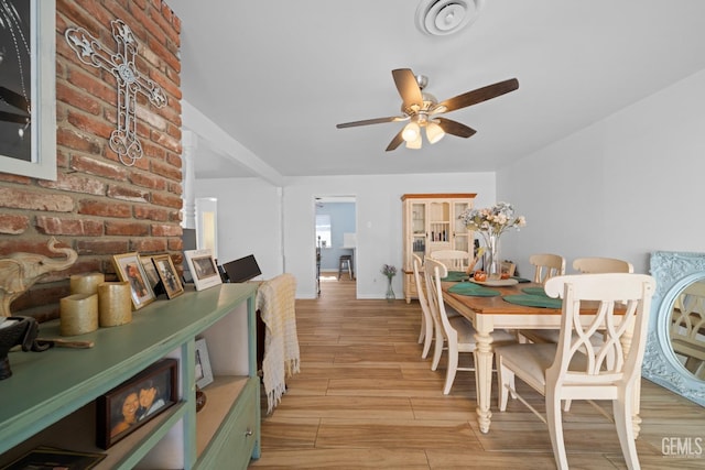 dining room with a ceiling fan, wood tiled floor, and visible vents