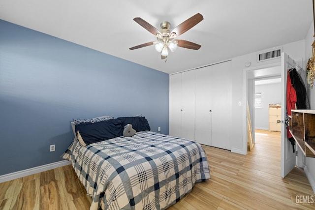 bedroom featuring a ceiling fan, baseboards, visible vents, and light wood finished floors