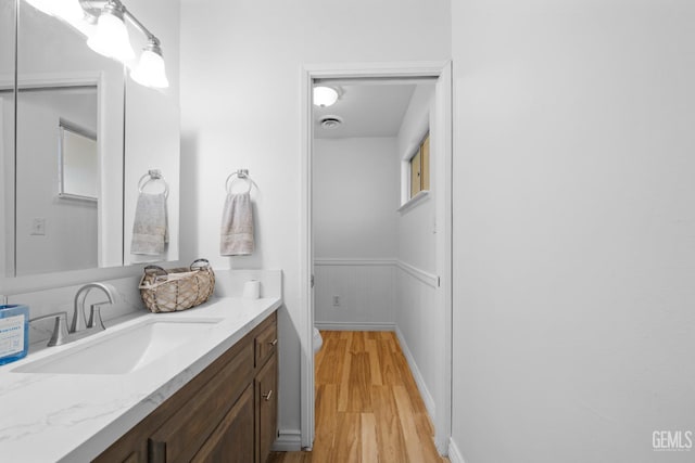 bathroom featuring a wainscoted wall, vanity, and wood finished floors