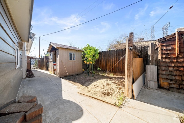 view of patio / terrace featuring an outbuilding, a fenced backyard, and a storage shed