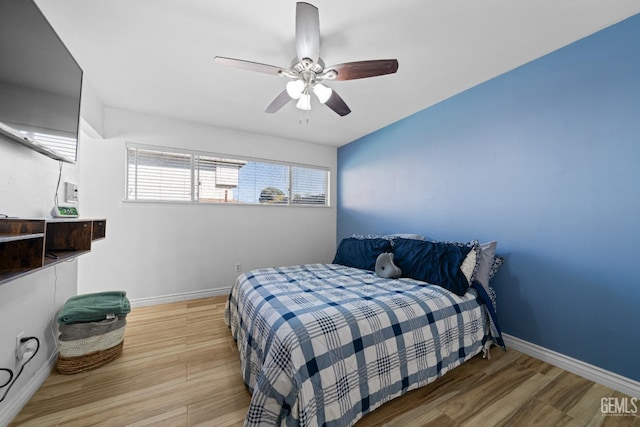 bedroom with a ceiling fan, baseboards, and wood finished floors