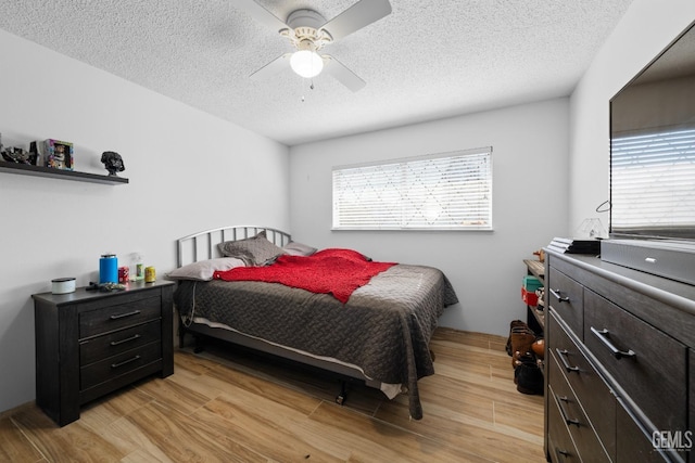 bedroom featuring a textured ceiling, light wood finished floors, and multiple windows