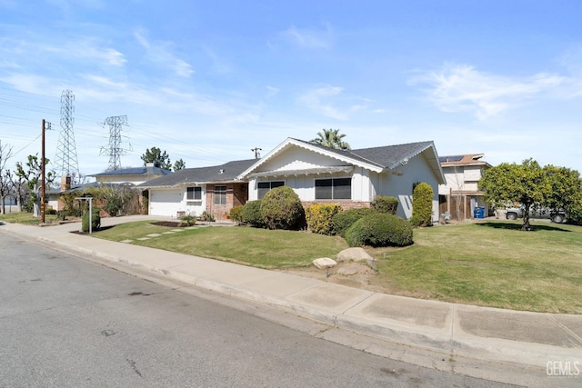 ranch-style home with an attached garage, driveway, and a front yard