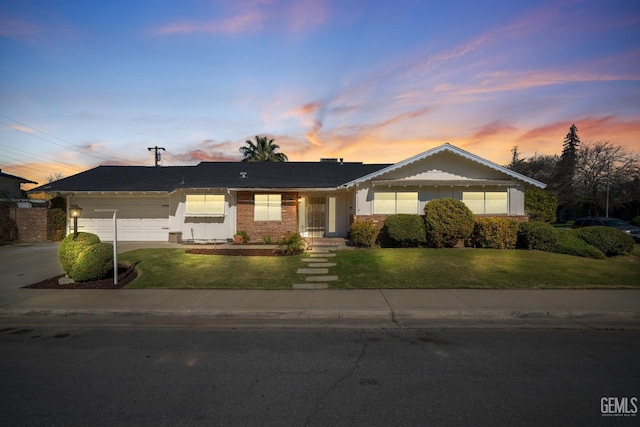 single story home with a garage, a front yard, and driveway