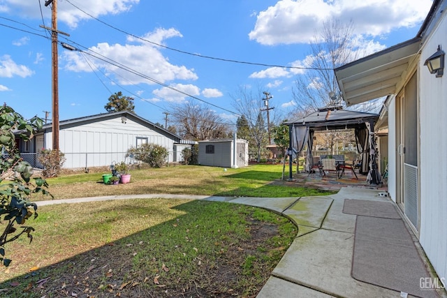 view of yard with a gazebo, a storage shed, and a patio