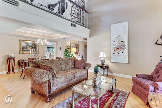 living room featuring baseboards, a notable chandelier, wood finished floors, and visible vents