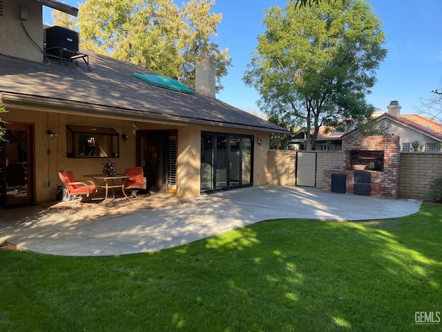 rear view of house featuring a lawn, fence, a patio area, and stucco siding