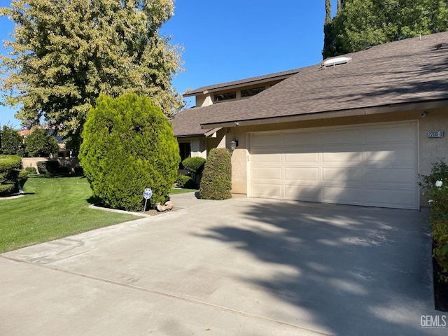 view of front of home featuring a garage, a front yard, roof with shingles, stucco siding, and driveway