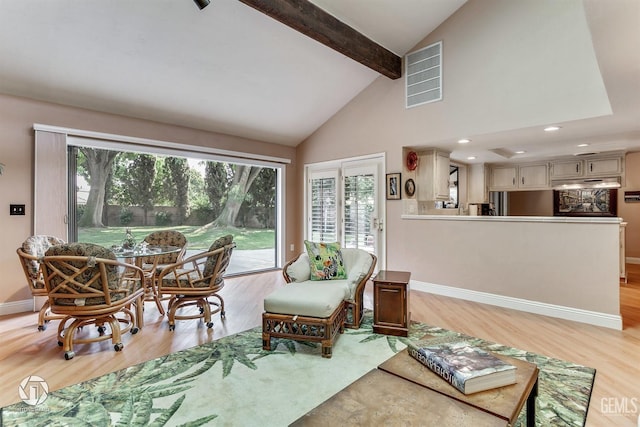 living area with baseboards, beamed ceiling, light wood-type flooring, and visible vents