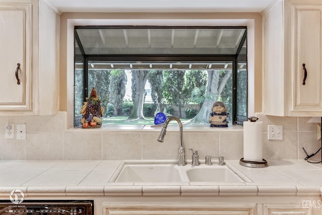 room details featuring a sink, dishwashing machine, tile countertops, and backsplash
