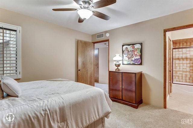 bedroom with a ceiling fan, light colored carpet, connected bathroom, and visible vents