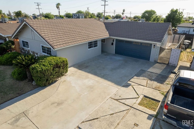 631 Union St, Delano, CA 93215 - view of front of house with a tiled roof, stucco siding, a garage, a gate, and concrete driveway