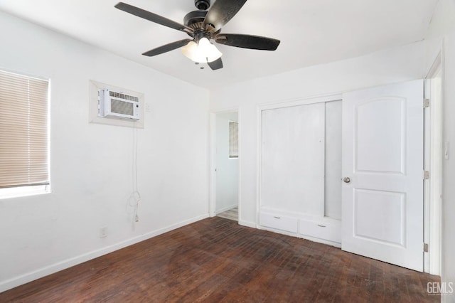 unfurnished bedroom featuring baseboards, a ceiling fan, wood finished floors, a wall mounted air conditioner, and a closet