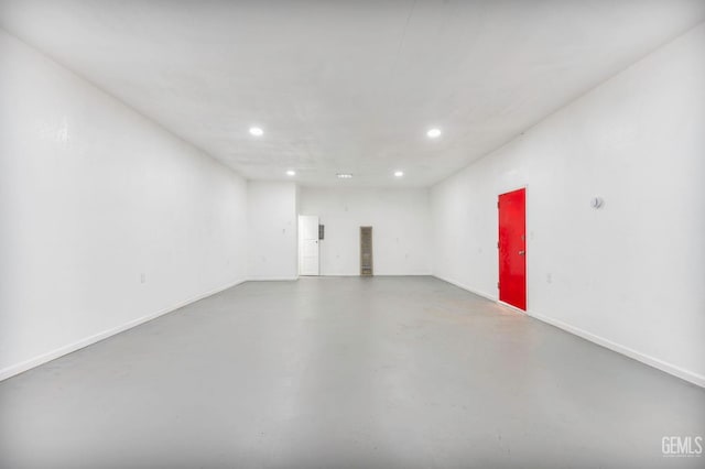 empty room with baseboards, concrete flooring, and recessed lighting