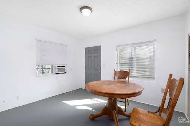 dining area with cooling unit and a textured ceiling