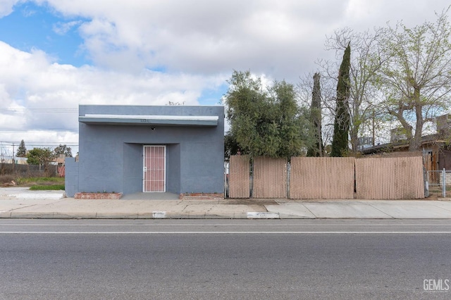 view of front of house featuring fence and stucco siding