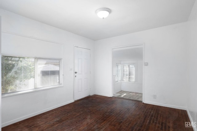 unfurnished room with wood-type flooring and baseboards