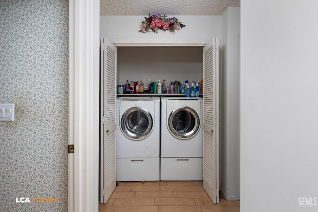 washroom with laundry area, wood tiled floor, separate washer and dryer, and a textured ceiling